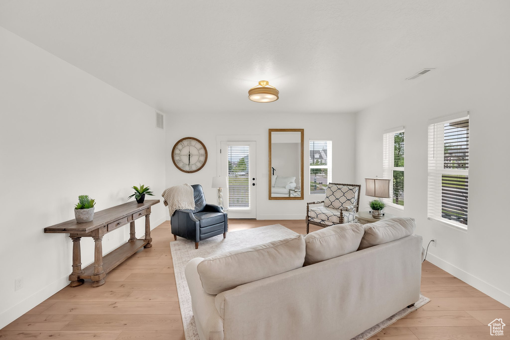 Living room with plenty of natural light, light wood-style floors, and baseboards