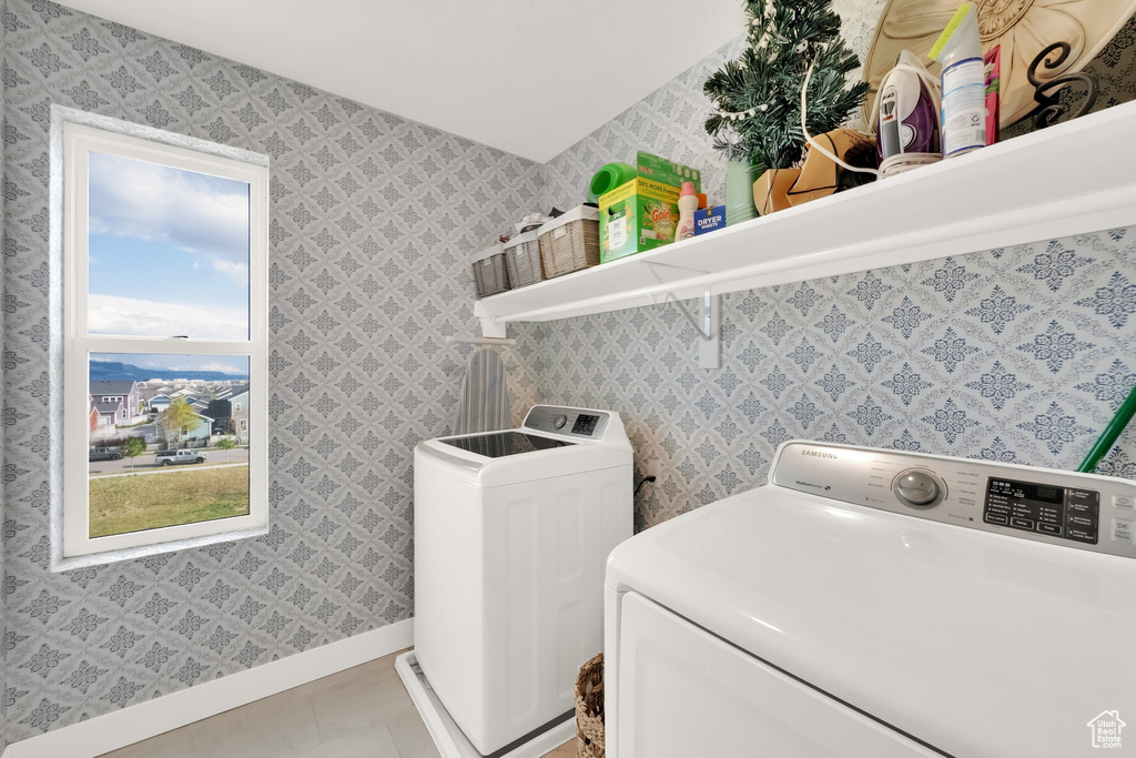 Laundry room with independent washer and dryer, baseboards, and tile patterned floors