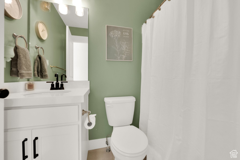 Full bath with vanity, toilet, and curtained shower