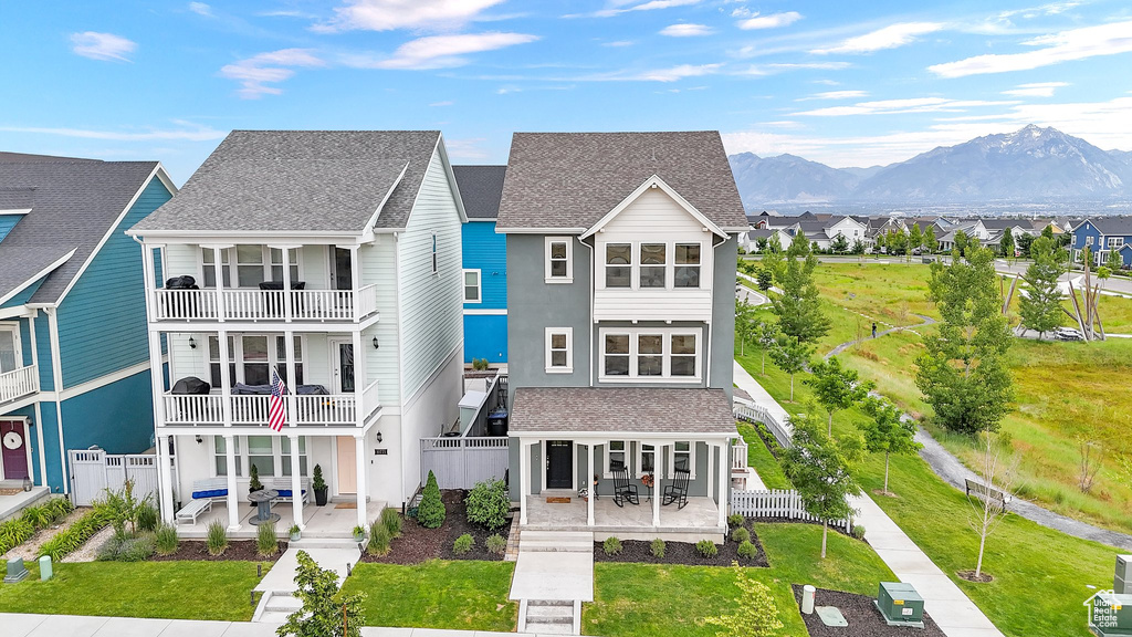 View of front of property featuring a patio area, a mountain view, a residential view, and a shingled roof