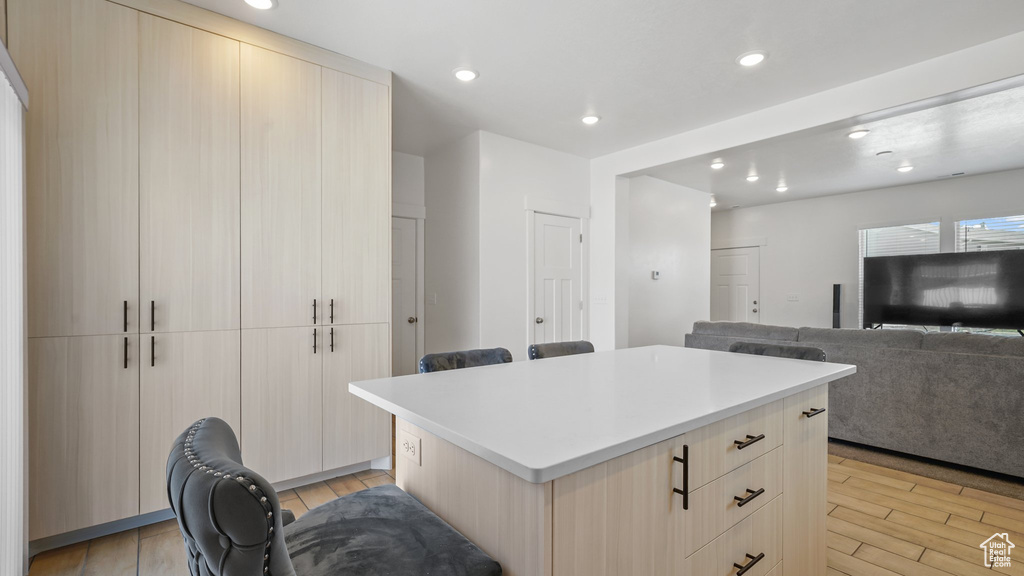 Kitchen with a kitchen island, recessed lighting, light countertops, modern cabinets, and light wood-type flooring