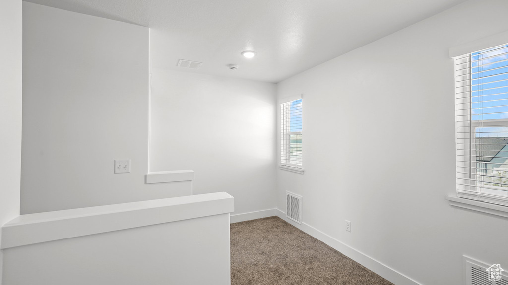 Empty room featuring carpet flooring and baseboards