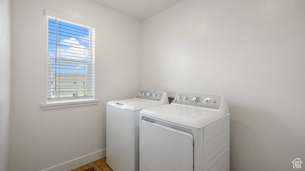 Laundry area featuring independent washer and dryer, baseboards, and wood finished floors