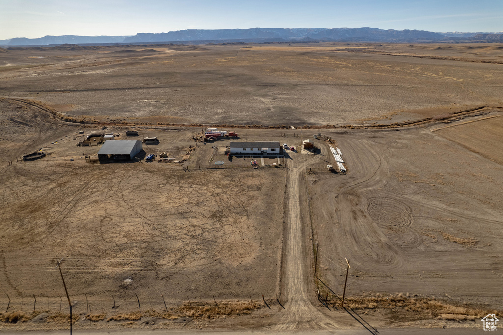 Aerial view of property and surrounding area featuring rural landscape, a desert landscape, and a mountain backdrop