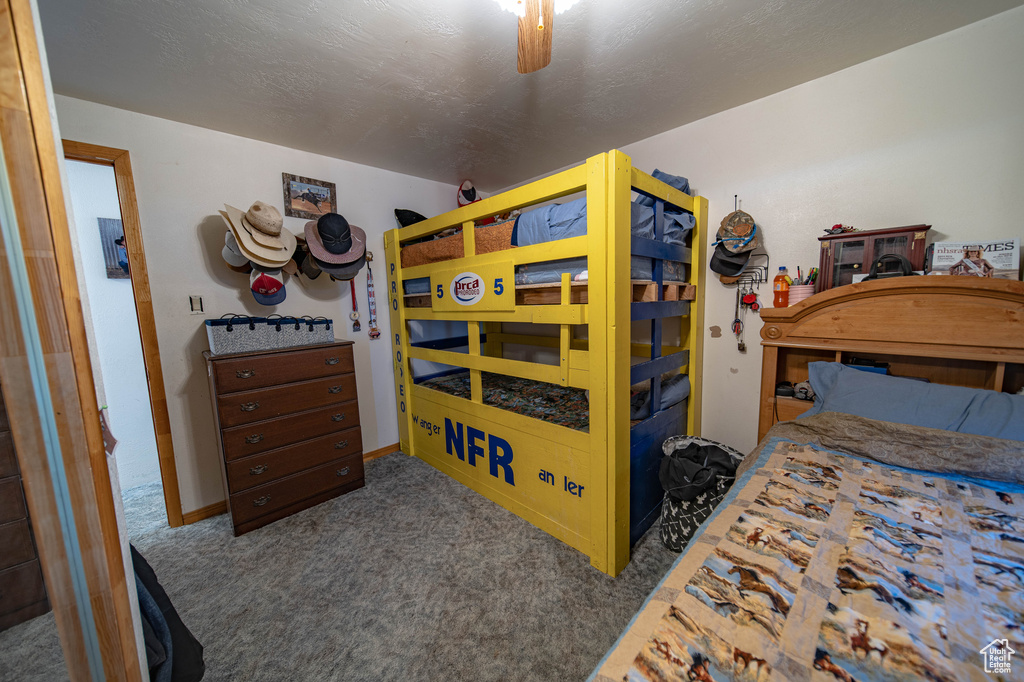 Carpeted bedroom featuring a ceiling fan