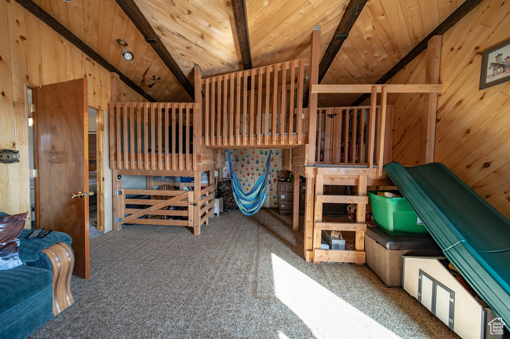 Bedroom featuring carpet flooring, wooden ceiling, and wooden walls