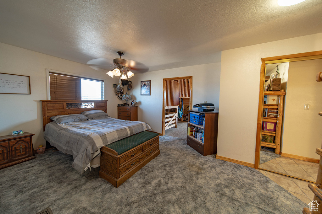 Bedroom with a textured ceiling, ceiling fan, and baseboards