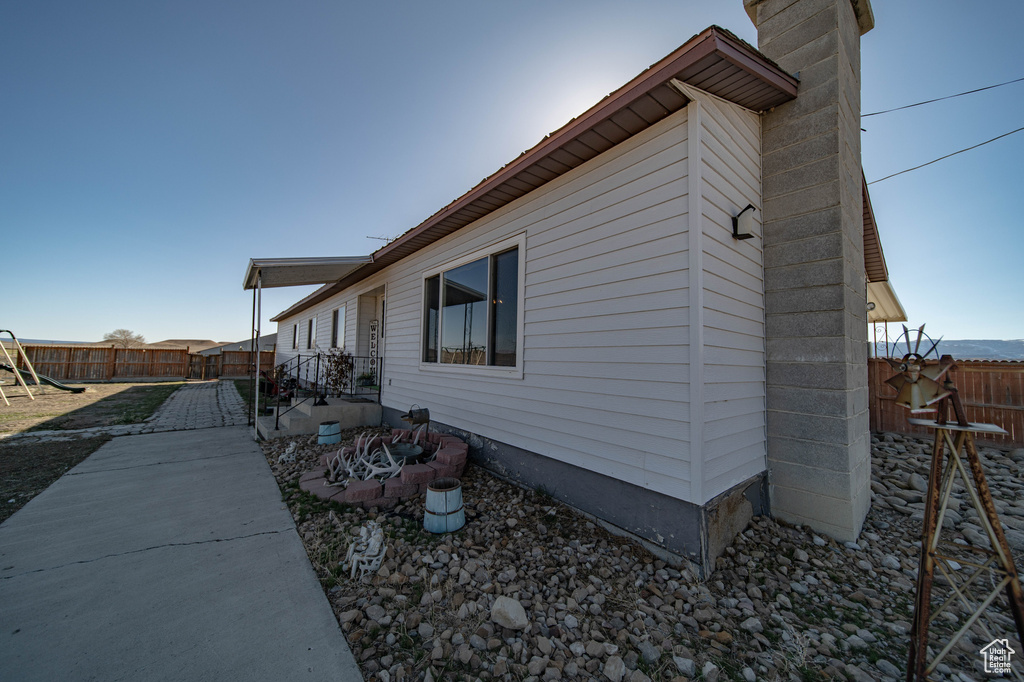 View of side of home featuring a chimney and a patio area
