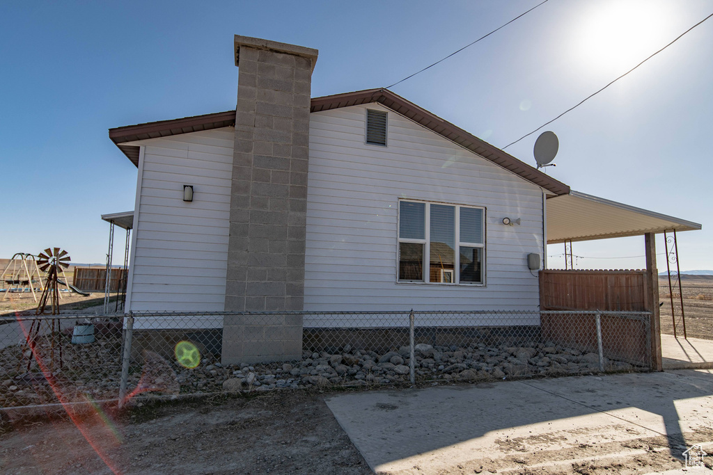 View of home's exterior featuring a chimney and a carport