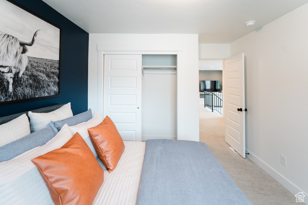 Carpeted bedroom with a closet and baseboards
