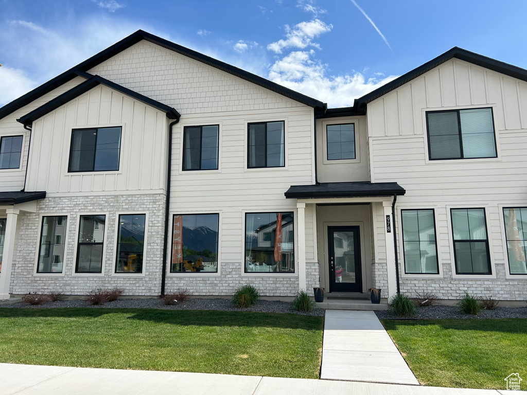 Multi unit property with board and batten siding and a front yard