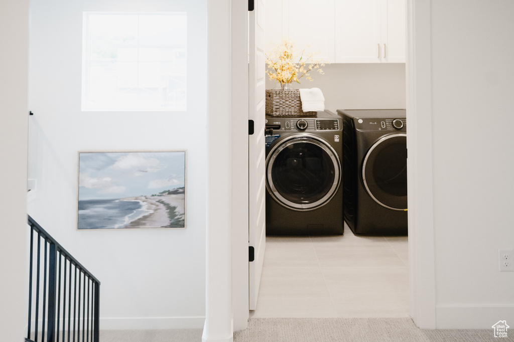 Laundry area featuring washer and clothes dryer and cabinet space