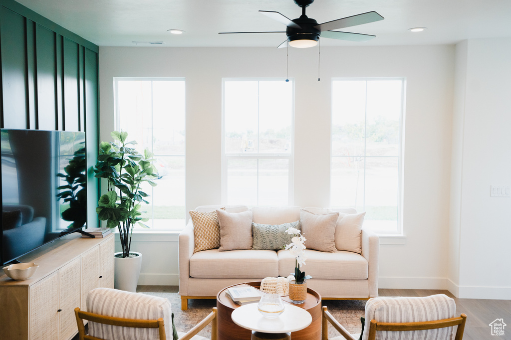 Living room with light wood-style flooring, ceiling fan, baseboards, and recessed lighting