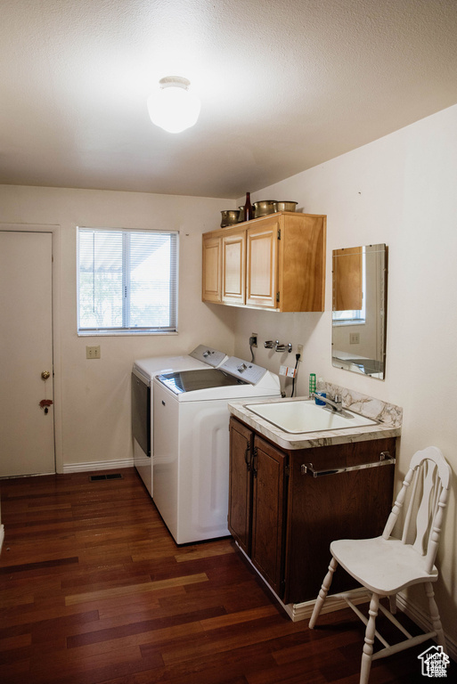 Laundry area featuring cabinet space, dark wood-style floors, washer and dryer, and baseboards
