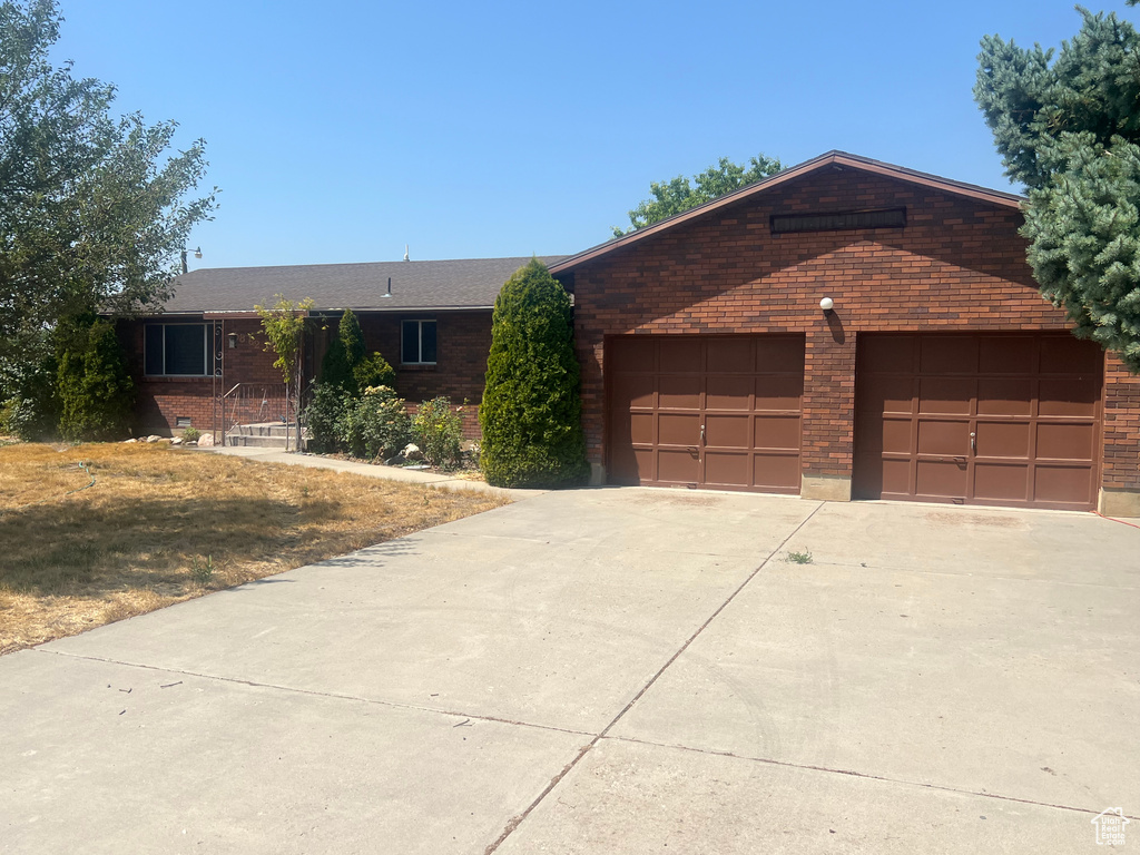 Ranch-style home featuring brick siding, concrete driveway, and a garage