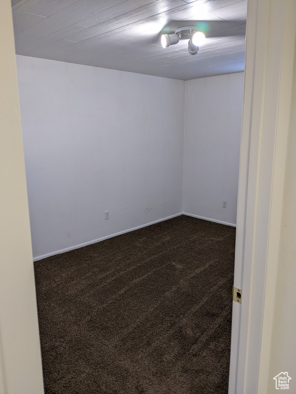 Spare room featuring dark colored carpet