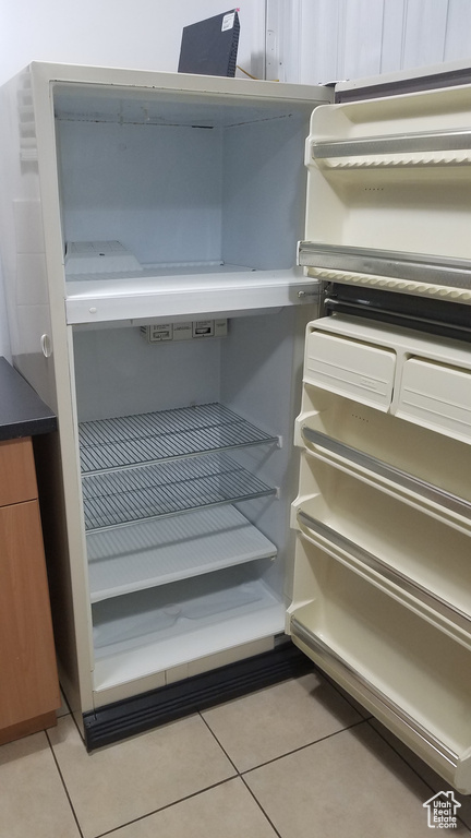 Detailed view of freestanding refrigerator and brown cabinets