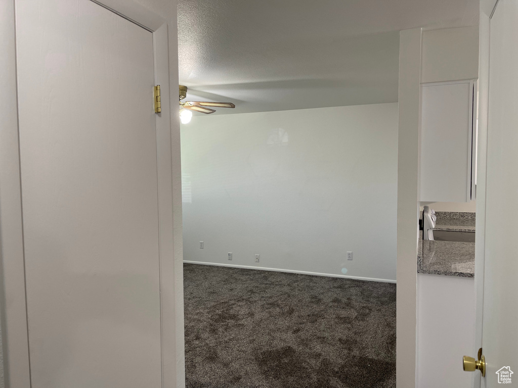 Unfurnished room featuring carpet flooring, a ceiling fan, and baseboards