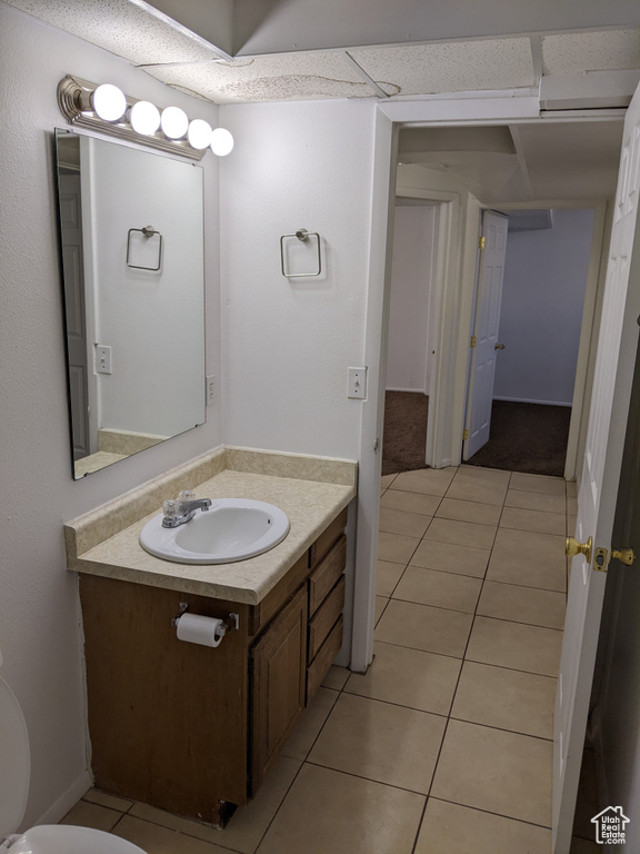 Half bathroom with vanity and tile patterned floors