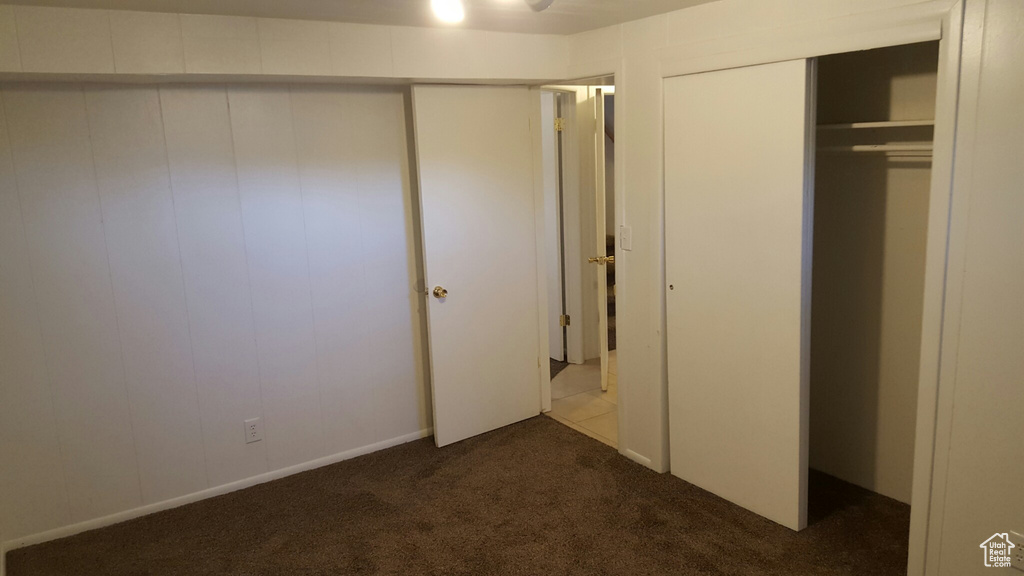Unfurnished bedroom featuring dark colored carpet