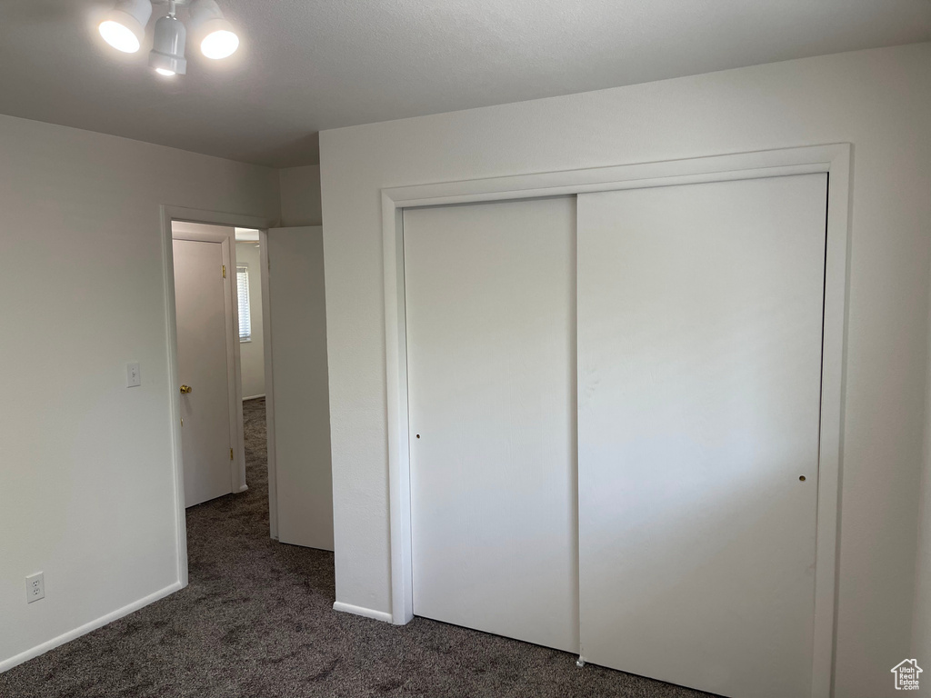 Unfurnished bedroom with carpet flooring, a closet, and baseboards