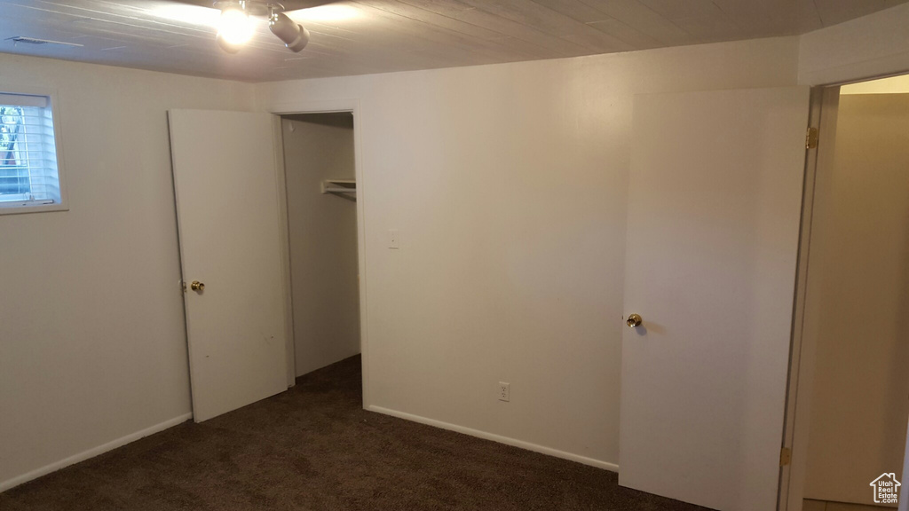 Unfurnished bedroom featuring dark carpet