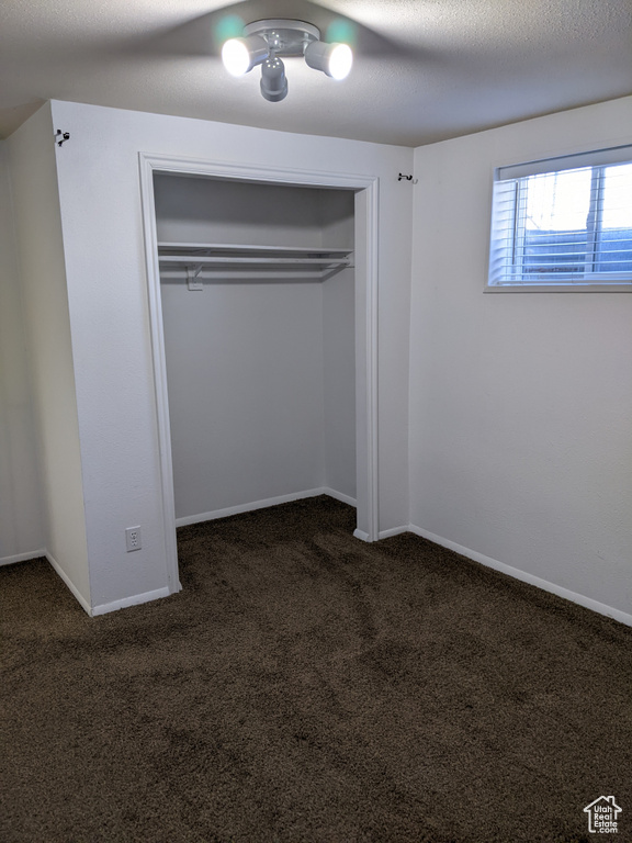 Unfurnished bedroom featuring carpet flooring, a closet, a ceiling fan, and baseboards