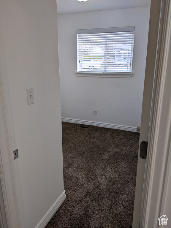 Unfurnished room featuring carpet and baseboards