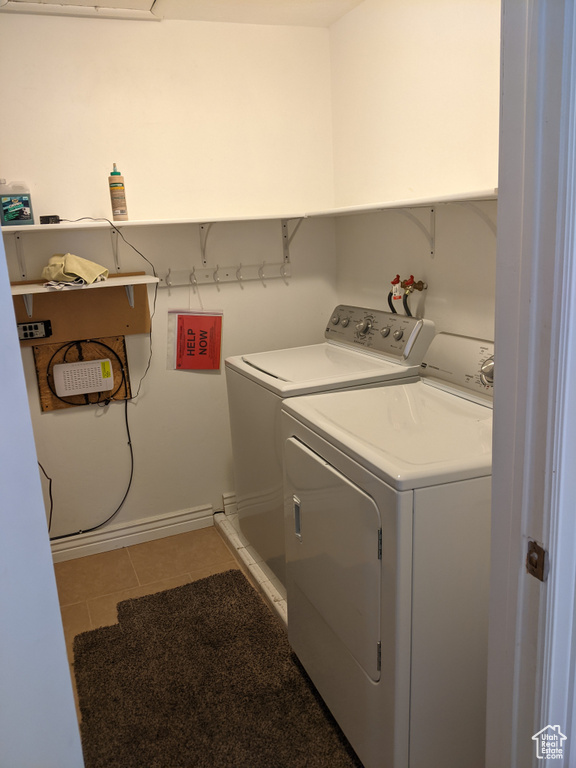 Laundry area featuring washer and dryer, tile patterned floors, and baseboards