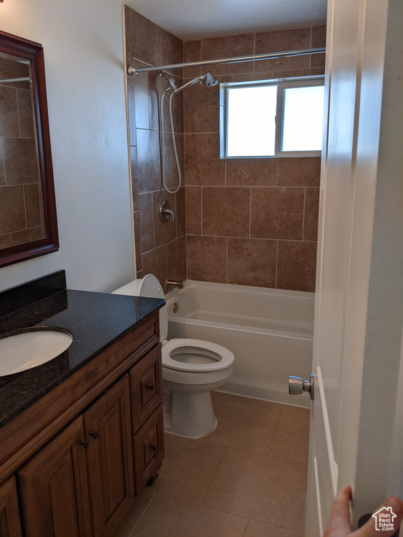 Bathroom featuring vanity, shower / bathtub combination, toilet, and tile patterned flooring
