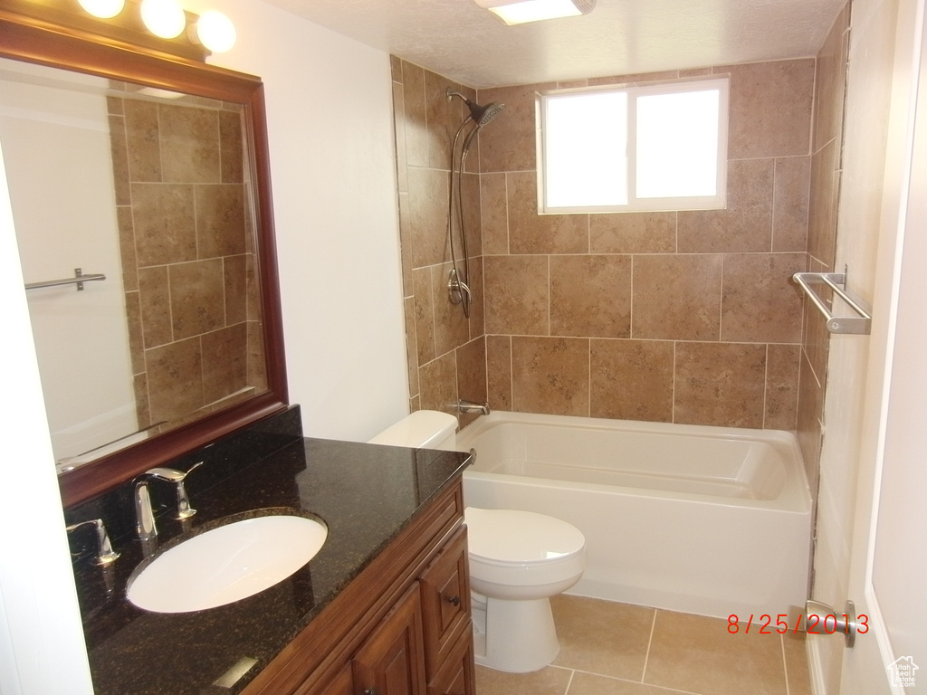 Bathroom with vanity, bathtub / shower combination, toilet, and tile patterned floors