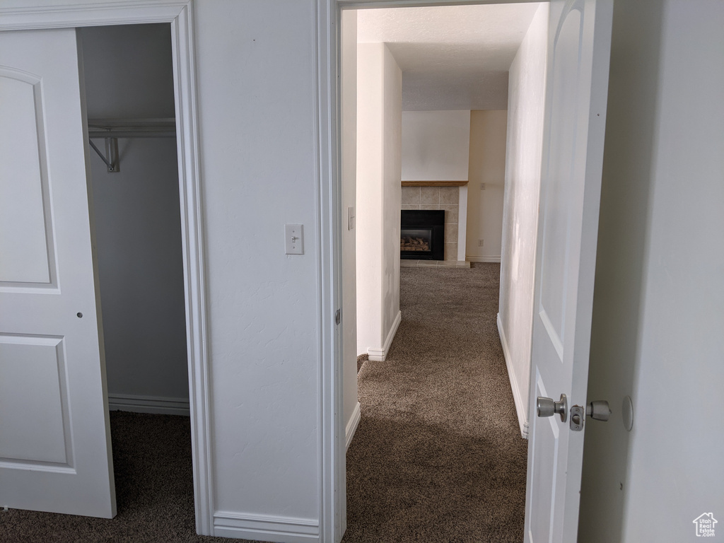 Corridor with dark colored carpet and baseboards