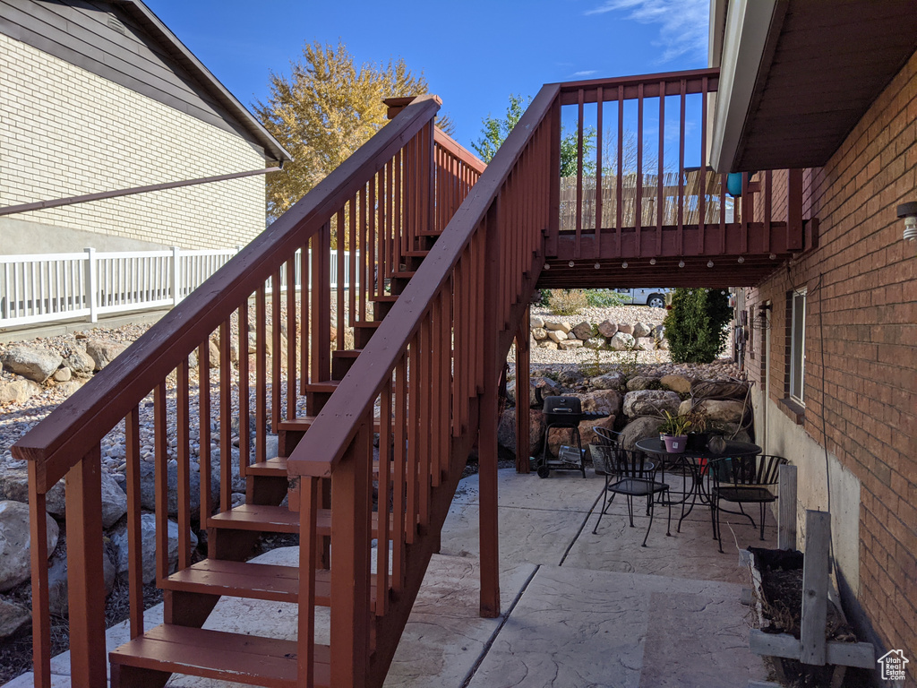 Wooden deck with stairway and a patio