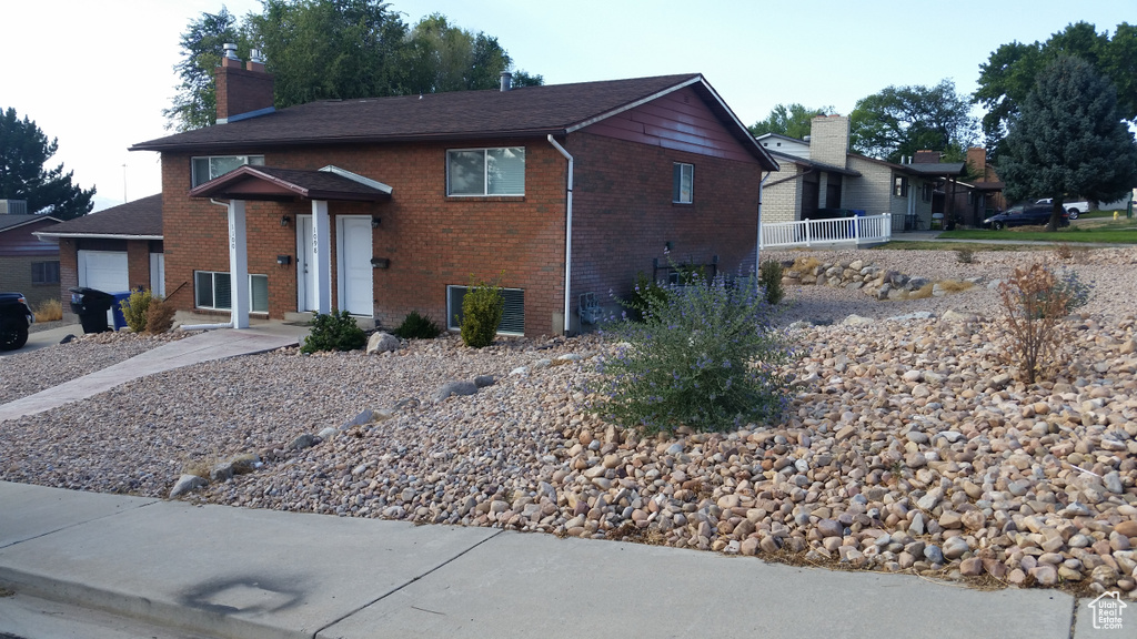 View of front of home featuring a chimney and brick siding