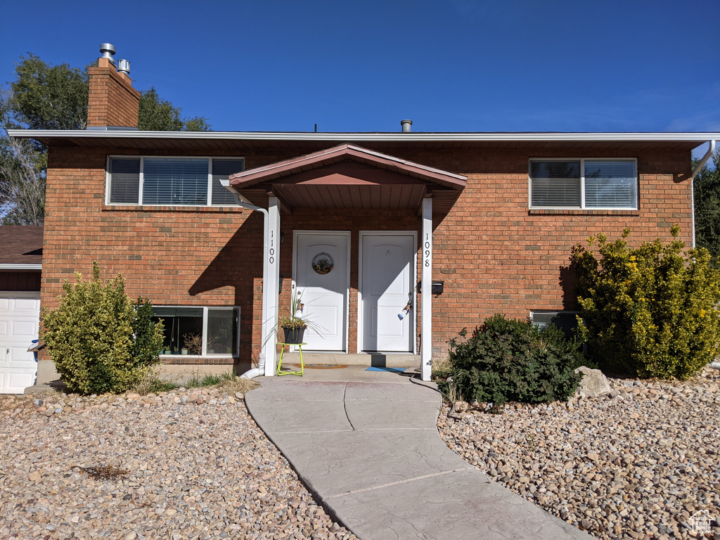 View of front of property featuring brick siding and a chimney