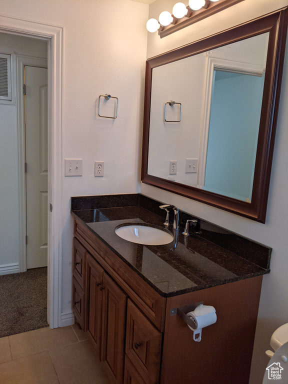 Bathroom featuring vanity, toilet, and tile patterned floors