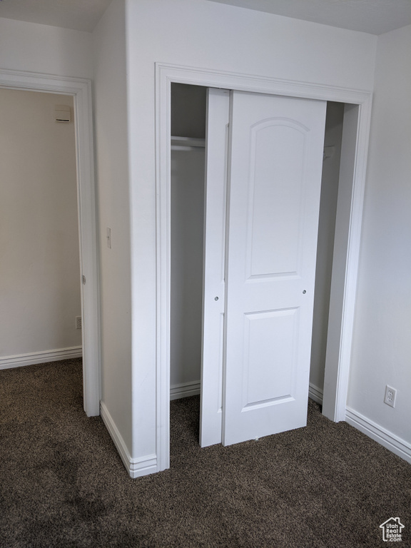 Unfurnished bedroom with carpet flooring, a closet, and baseboards