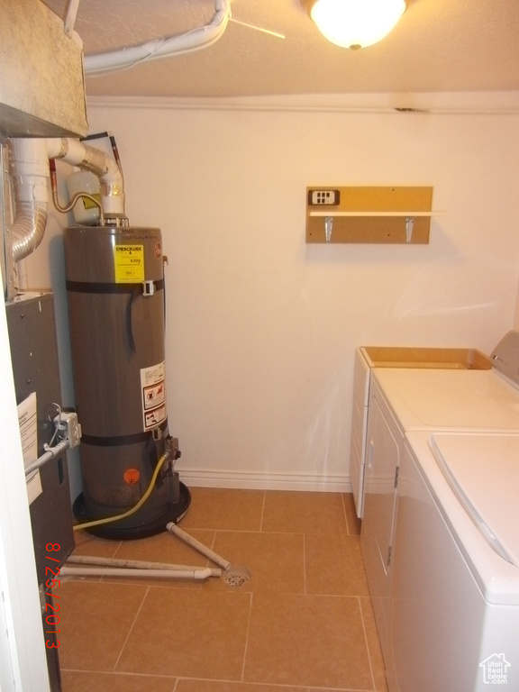 Laundry room with independent washer and dryer, water heater, light tile patterned flooring, baseboards, and ornamental molding
