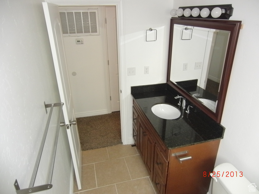 Bathroom featuring vanity, toilet, and tile patterned floors