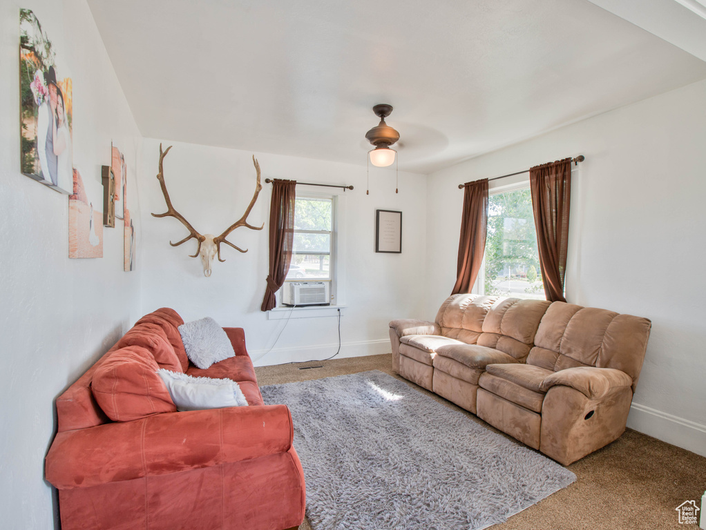 Living room featuring carpet flooring, cooling unit, ceiling fan, and baseboards