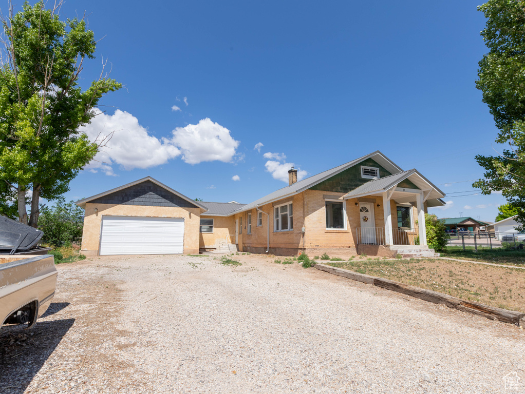 Single story home featuring dirt driveway, a chimney, and brick siding
