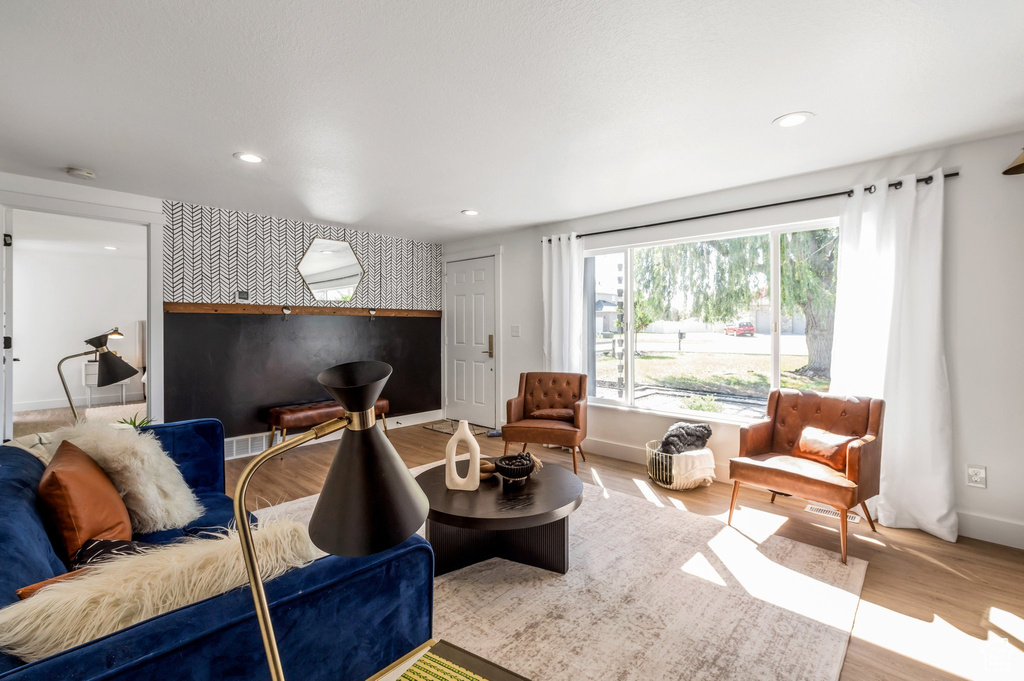 Living area featuring baseboards, recessed lighting, wood finished floors, and an accent wall