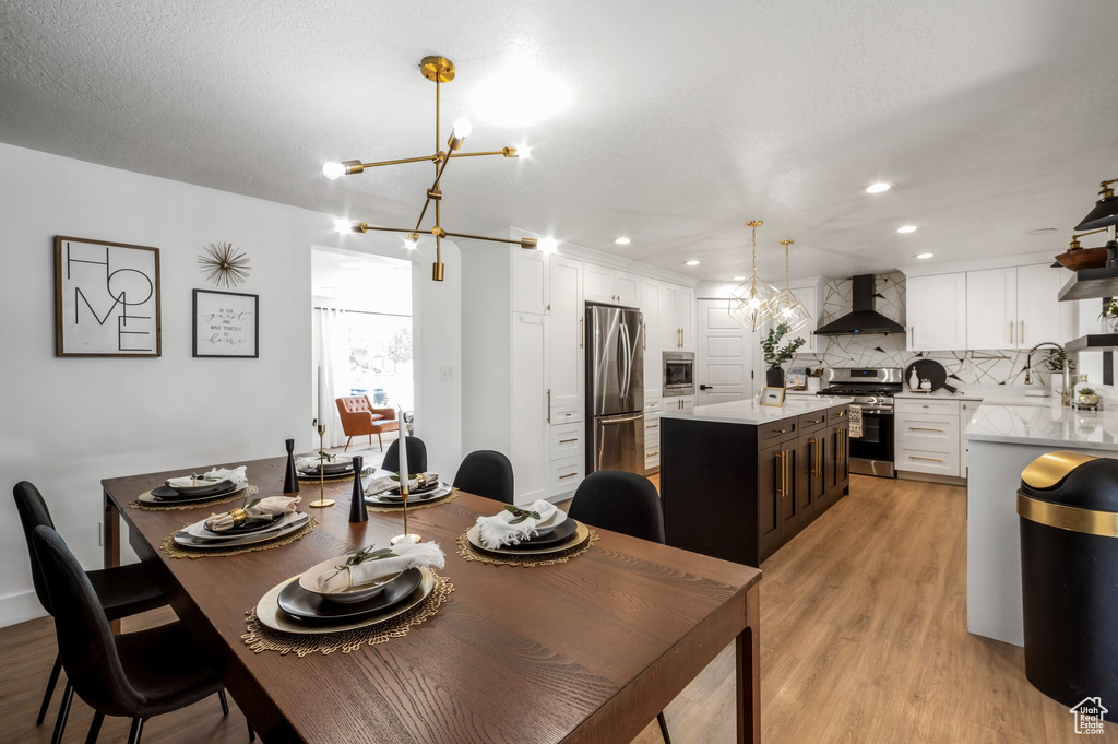 Dining space featuring light wood finished floors, a chandelier, and recessed lighting