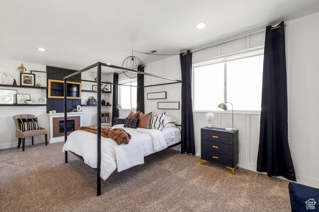 Bedroom featuring carpet flooring, recessed lighting, and a glass covered fireplace