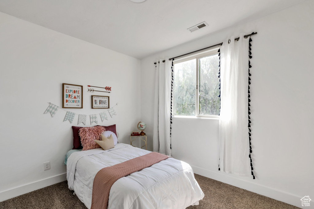 Bedroom featuring carpet and baseboards