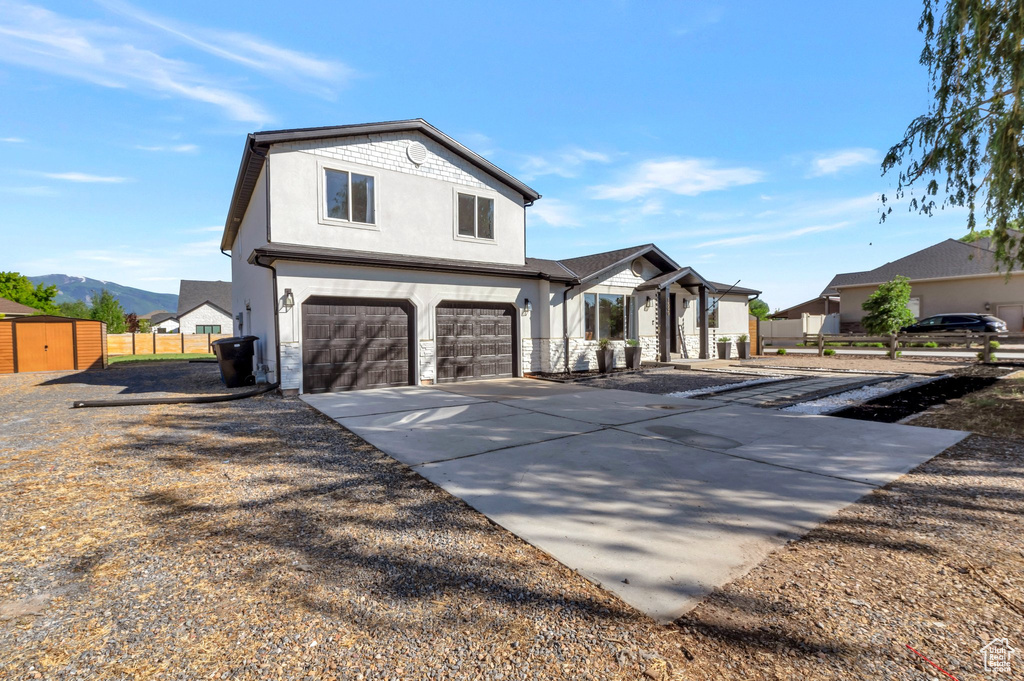 View of front of house with stucco siding, an attached garage, concrete driveway, and a mountain view