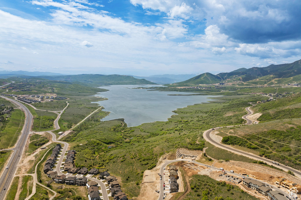 Aerial view of property and surrounding area featuring a water and mountain view