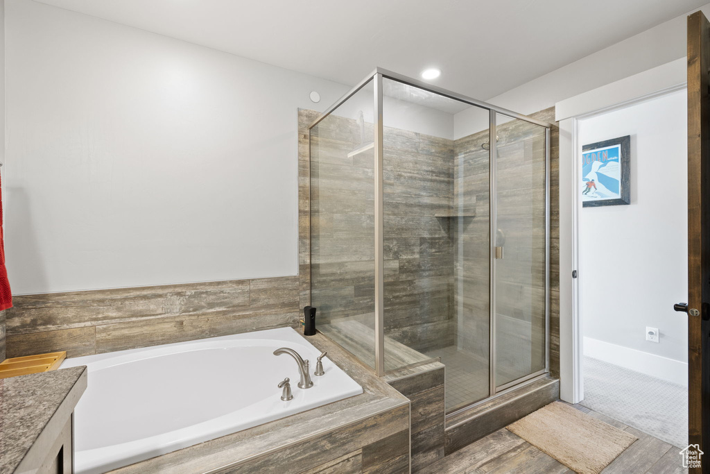 Bathroom with a bath, vanity, and a stall shower