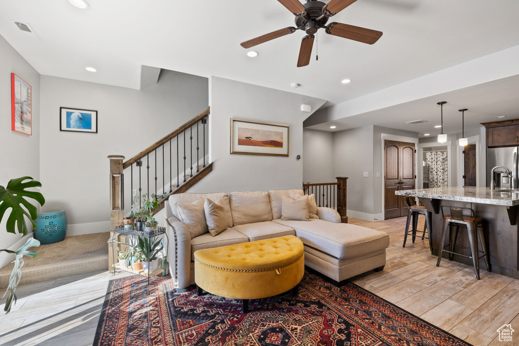 Living room featuring baseboards, ceiling fan, recessed lighting, stairs, and light wood-type flooring