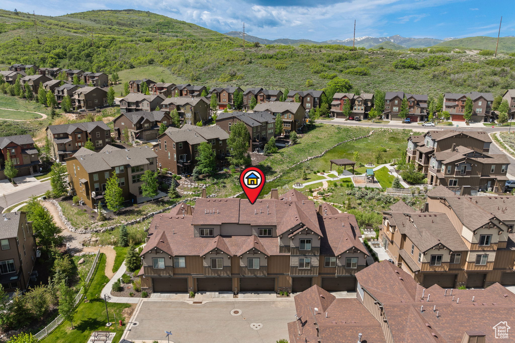 Aerial view of property and surrounding area featuring nearby suburban area and mountains